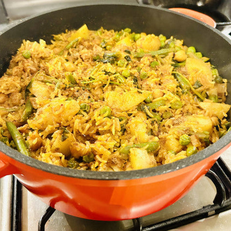 Pilav with vegetables in a red pot on a stove